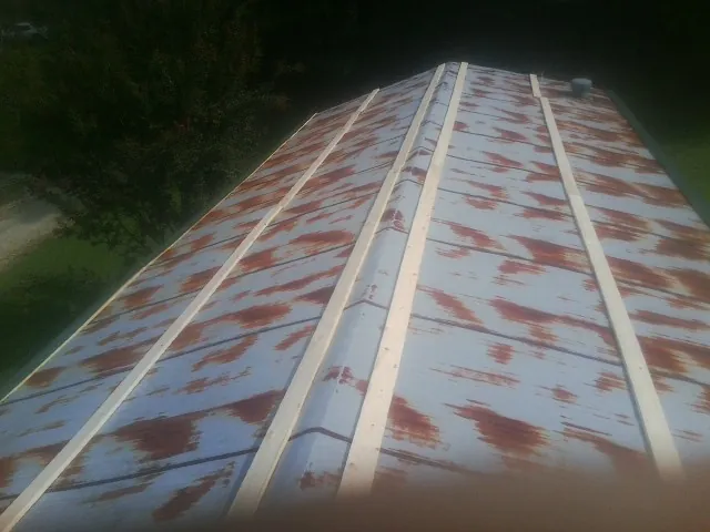 Rusted metal roof panels with new wood purlins before replacement — Storm Damage Roof Repair in Jasper by Roofing Brothers